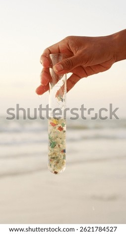 Hand holds sample of microplastic pollution, ocean plastic, polluted water, single-use waste, environmental concept, sea contamination