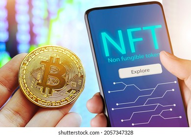 Hand holds smartphone with bitcoin cryptographic NFT blockchain marketplace,Cryptoart concept
