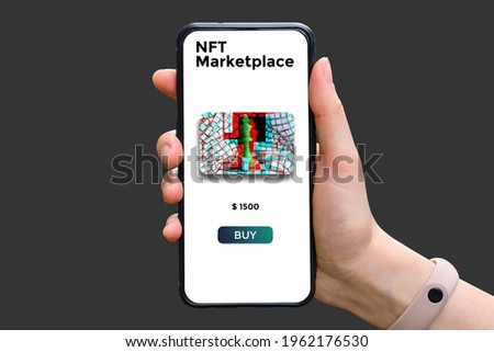 Hand holds smartphone with type of cryptographic NFT marketplace with art sale