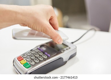 Hand Holds Smartphone Via NFC Reader During Contactless Payment In Retail