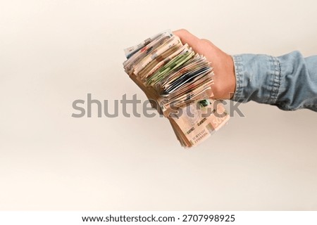 hand holds a substantial stack of paper money, Ukrainian hryvnia. concepts of wealth, economic growth and financial opportunity on white background. male hand displays a thick bundle of cash,