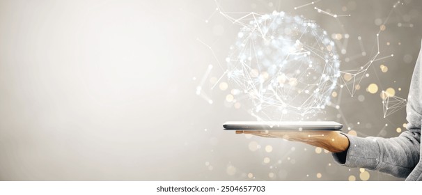 A hand holds a tablet with a holographic digital sphere on a light background. Represents data networking, global information exchange, and technology