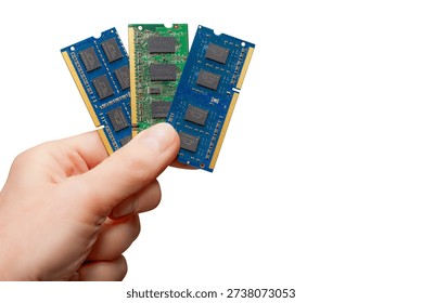 A hand holds three memory modules representing different types of DRAM memory. The lack of supply affects many devices and markets.