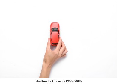 Hand Holds A Toy Car On A White Background