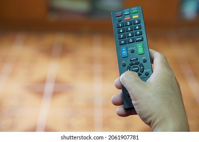 Hand holds TV remote controller. Concept : electronics equipment, a remote control can be used to operate devices or appliances with variety functions. Entertainment. Facilitator.  - Shutterstock ID 2061907781