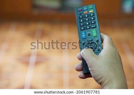 Hand holds TV remote controller. Concept : electronics equipment, a remote control can be used to operate devices or appliances with variety functions. Entertainment. Facilitator. 