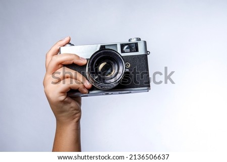 hand holds vintage SLR camera isolated on white background