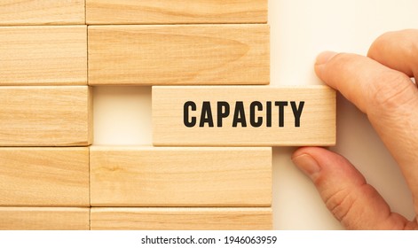 Hand holds a wooden cube with the text CAPACITY. Positive thinking concept - Shutterstock ID 1946063959