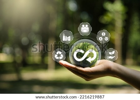Hand of human holding green earth circular economy icon. Circulating in an endless cycle, Business and world sustainable environment concept.
