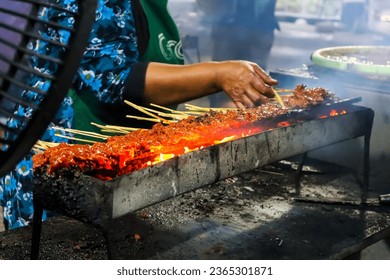 Hand of indonesian woman preparing satay in traditional charcoal satay grill - Shutterstock ID 2365301871