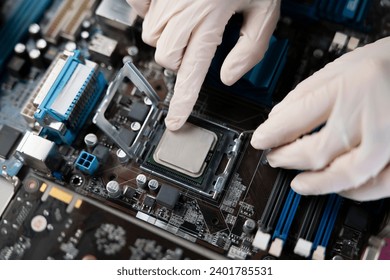 hand insert processor cpu chip in the socket of motherboard, computer assembly process