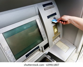 Hand inserting ATM card into bank machine to withdraw money - Shutterstock ID 639811807