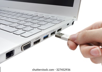 Hand inserting white USB cable into laptop isolated on white background - Shutterstock ID 327452936