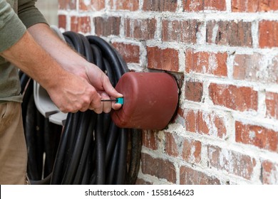 Hand Installs Faucet Cover To Protect The Plumbing From Freezing In The Winter