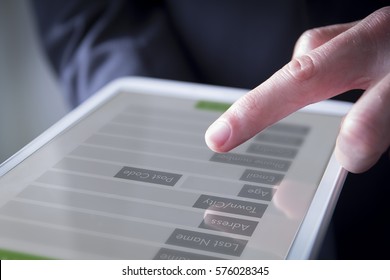 Hand Interacting With Digital Form On The Screen Of A Tablet. All Graphics Are Made Up.