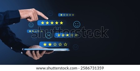 Hand interacting with a digital rating system on a tablet, showing stars and emoticons on a dark background. Concept of online reviews and feedback