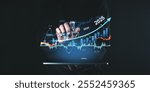 A hand interacting with futuristic financial charts for 2025 on a digital screen. Dark background. Concept of future market forecast and growth trends