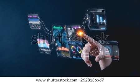 A hand interacts with futuristic virtual data screens displaying analytics and charts on a dark background.