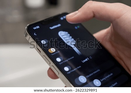 A hand interacts with a smartphone app interface showing various smart electric toothbrush settings, including the convenient Travel Mode option, symbolizing modern personalized oral care technology