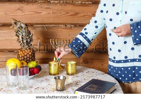 The hand of a Jewish religious woman lights Shabbat candles at the table. horizontal photo Foto stock © 