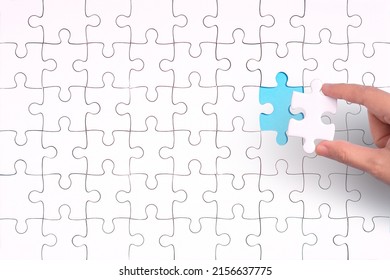 hand jigsaw puzzle pattern missing piece White jigsaw puzzle pattern top view to express alliance union team working solution success problem. Business assemble metaphor or puzzles game challenge.