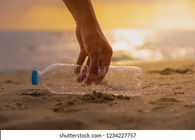 Hand Keep  Cleanup  The Plastic Bottle On Beach At The Sunset Scene