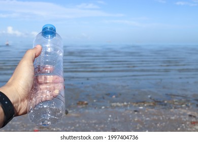 Hand Keep Cleanup The Plastic Bottle On Beach. Ecology Concept