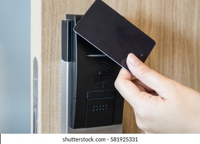 Hand with Key card at Wooden Door