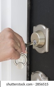 hand with key unlocking the front door