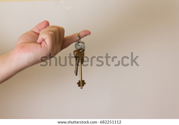 Hand with keys on a light\
background