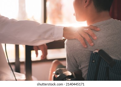 Hand Of A Kind Doctor Encourage To Young Man With Disability In Examination Room, Activity In Hospital ,home,quarantine,Symptom Monitoring And Consultation By A Specialist,Healthcare Concept.