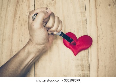 hand with a knife stabbing into a red heart 