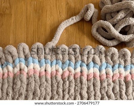 Hand Knitting With Chunky Loop Yarn On Wooden Table