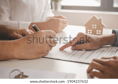 Hand of landlord, realtor pointing sign signature contract rental, purchase, buyer home or apartment with tenant, client after banker agreement mortgage, loan success or done. Property agent concept.