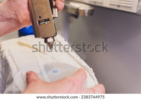 Hand Laundry worker in the process of removing stains by using a special dry-cleaning
