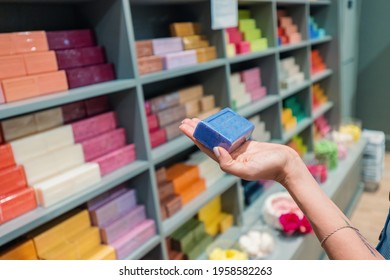 Hand With Lavender Herbal Soap On The Background Of Shelves With A Range Of Products For Body Care And Bathroom Cosmetics