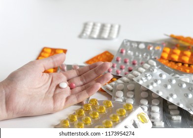 Hand Laying On The Table Full Of Medicines. Drug Abuse, Overdose, Addiction. Drug Safety Concept.                              