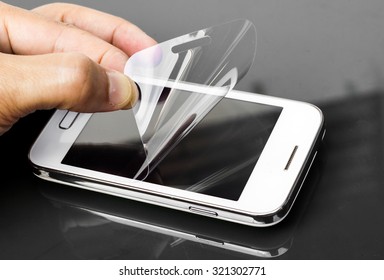 Hand Laying Scratch Protective Film On A Smartphone