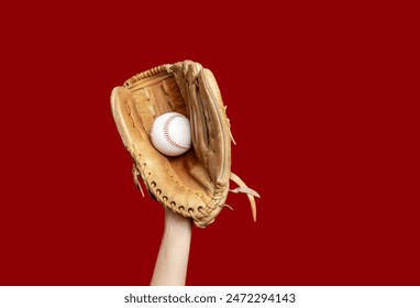 Hand in leather baseball glove holds white baseball on red background. High-quality photo. Winner - Powered by Shutterstock