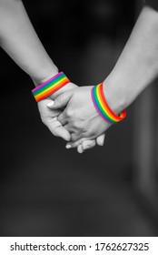 Hand Of LGBT Women Holding Together With Rainbow Ribbon Symbol; Concept Of LGBT Pride, LGBTQ People, Lgbt Rights Campaign. BLACK AND WHITE PHOTO 