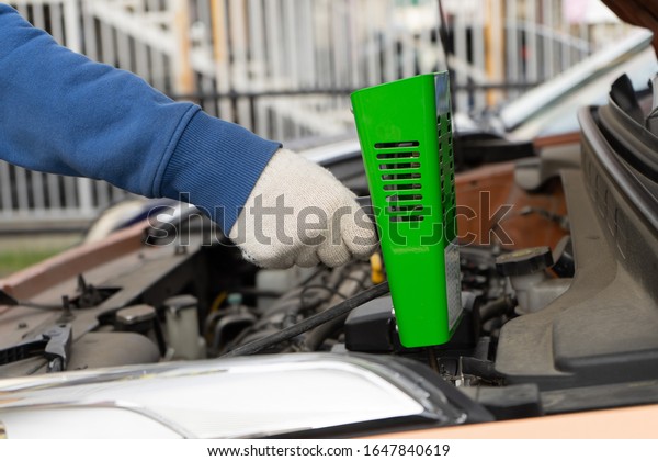 Hand with a\
load fork to check the car\
battery.