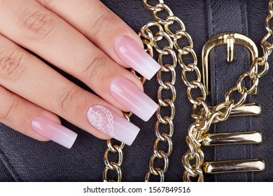 Hand and long artificial manicured nails and ombre gradient design in pink   white colors