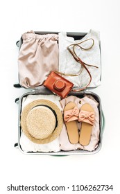 Hand Luggage With Stylish Female Clothes On White Background. Flat Lay, Top View. Summer Travel Fashion Concept.