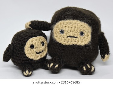 Hand Made Amigurumi Sasquatch and Child Bigfoot with Baby Isolated Against White Background Crocheted Yarn Art Stuffed Toy