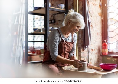 Hand made ceramics are formed by a mature woman on a potters wheel
 - Powered by Shutterstock