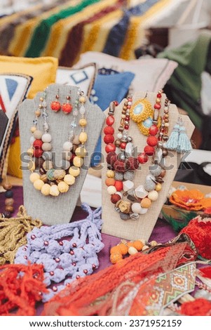 Hand made jewelry beads are made from old threads and other materials reused at the fair. Slow fashion, ecological craft production