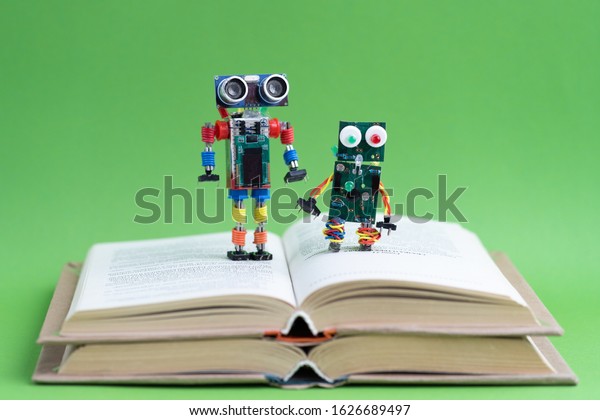 Hand made robot working on the arduino platform\
with books. Green background. Free space for text. STEM education\
for children and teenagers, robotics and electronics. DIY. AI.\
STEAM. Concept.