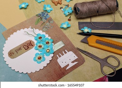 Hand Made Scrapbooking Post Card And Tools Lying On A Table 