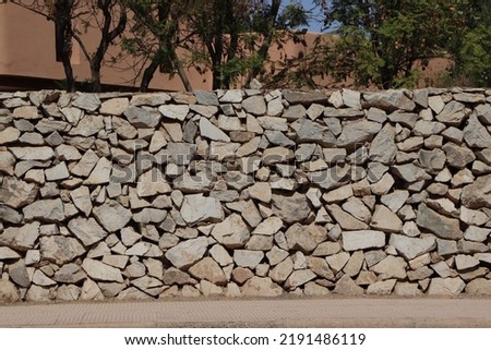 Hand made stonewall. Gray rough stonewall. Abstract stones textured background. Wall ancient construction method.