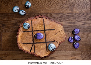 Hand Made Wood Burn Tic Tac Toe Game With Painted Rock Game Pieces; Blue And Purple Beetles And A Wooden X And O Game